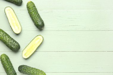 Yeşil ahşap arka planda taze salatalıklar.