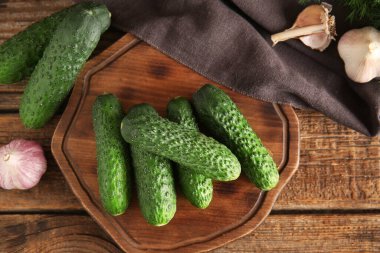 Tahtada taze salatalık ve ahşap kaplama sarımsak var.