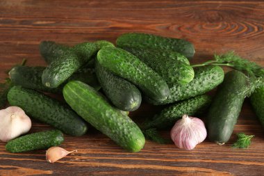 Sarımsaklı taze salatalık ve ahşap arka planda dereotu.