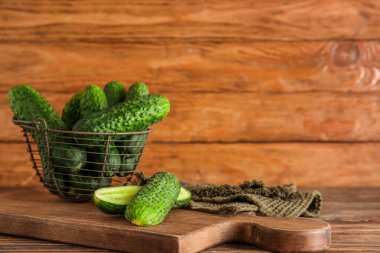 Tahta arka planda taze salatalık ve sepet.