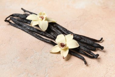 Aromatik vanilya çubukları ve pembe arka planda çiçekler