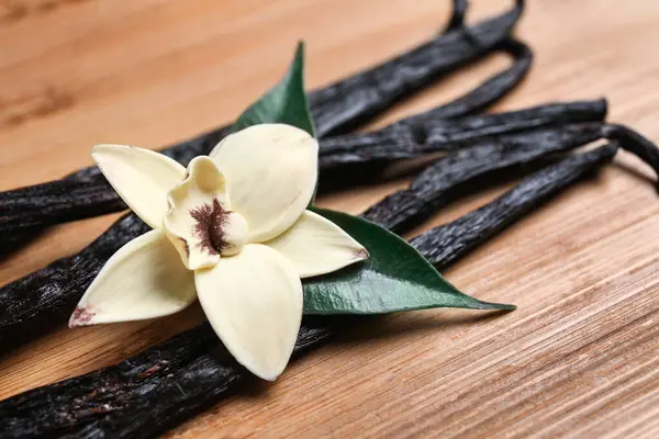 Aromatik Vanilya Çubukları Ahşap Arka Plan Üzerinde Çiçek — Stok fotoğraf