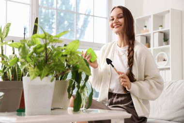 Evinde bahçe aletleri ve bitkileri olan genç bir kadın.