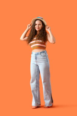 Güzel genç kadın turuncu zemin üzerine