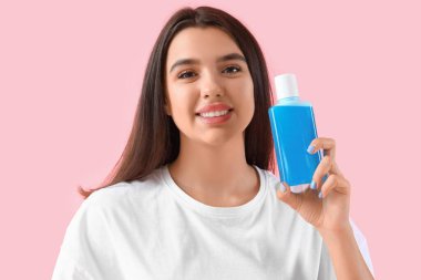 Gülümseyen, ağzı pembe arka planda durulanmış genç bir kadın, yakın plan.