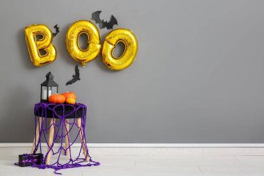 Oturma odasındaki gri duvara asılı balonlardan yapılmış dışkı ve mesaj bülteni.