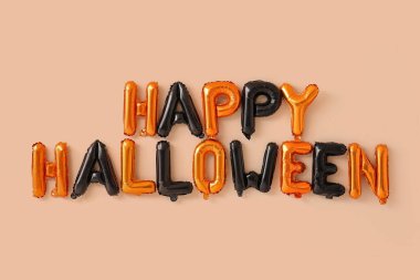 Bej duvarda asılı balonlardan yapılmış Cadılar Bayramınız kutlu olsun.