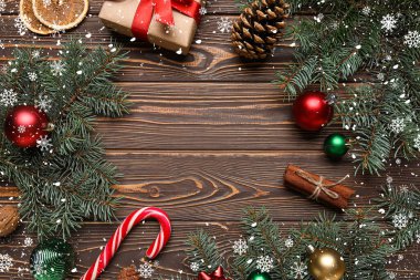 Noel ağacı dallarından yapılmış çerçeve ve ahşap arka planda süslemeler, üst manzara