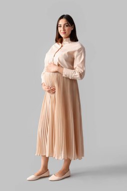 Hafif arka planda genç hamile bir kadın