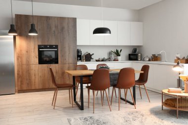 Modern mutfak, yemek masası ve parlayan lambalar.