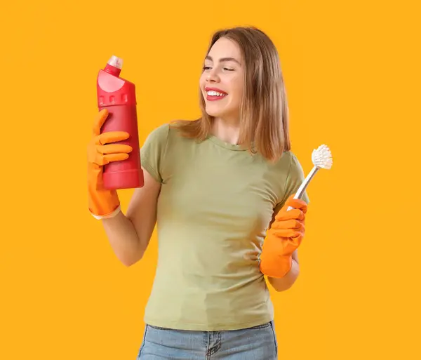 Mujer Joven Con Botella Detergente Cepillo Inodoro Sobre Fondo Naranja —  Fotos de Stock