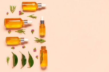Soluk turuncu arka planda bitkilerle ve çiçeklerle dolu farklı sağlıklı yağlardan şişeler.
