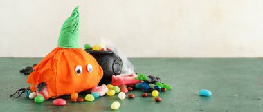 Cadılar Bayramı için kağıt balkabağı ve masada lezzetli şekerler. Tasarım için pankart