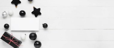 Boş kartıyla güzel bir Noel kompozisyonu, hediye kutusu ve beyaz ahşap arka planda metin için alanı olan bir dekor