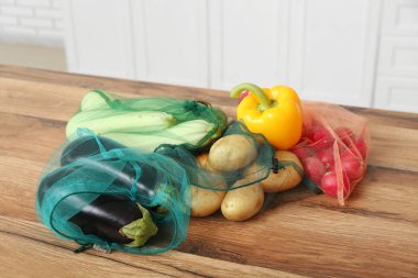 Mutfaktaki tezgahta farklı olgun sebzelerle çevrili eko poşetler, yakın plan.