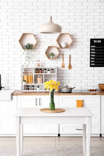 Mutfağın içindeki masada çiçek açan vazo.