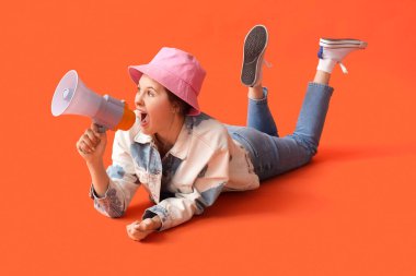 Kırmızı arka planda megafona bağıran genç bir kadın.