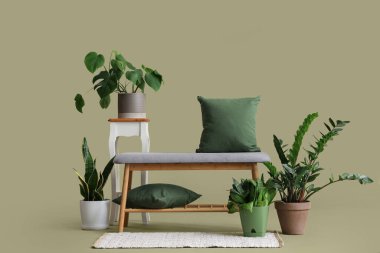 Yastıklı yumuşak bank ve yeşil arka planda bitkiler