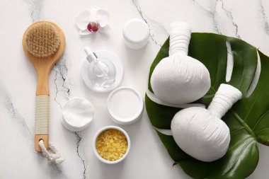 Açık arkaplanda spa aksesuarları, kozmetik ürünleri ve palmiye yaprağı olan kompozisyon