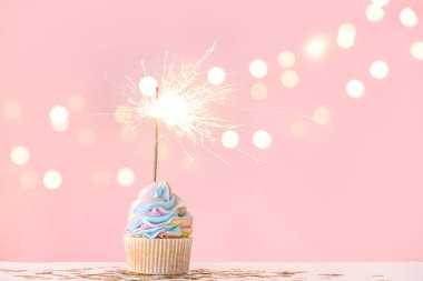 Lezzetli bir doğum günü keki. Arka planda maytap ve dekorla.