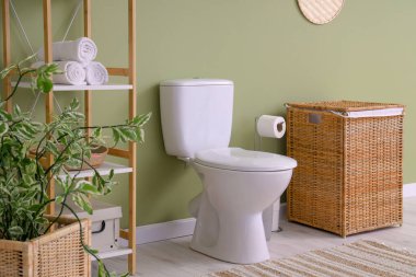 Tuvaletin içinde klozet, raf ünitesi ve sepet var.