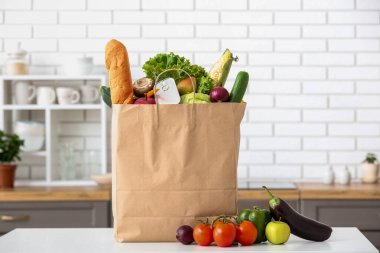 Mutfaktaki masada taze ürünlerle dolu bir alışveriş poşeti.