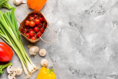 Domatesli kağıt torba, taze sebze ve grunge grisi arka planda mantar.