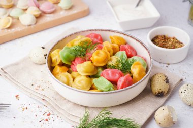 Beyaz arka planda dereotu ve bıldırcın yumurtalı kaynamış renkli börekler.