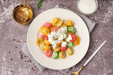 Ekşi kremalı ve dereotlu kaynamış renkli hamur köfteleri.