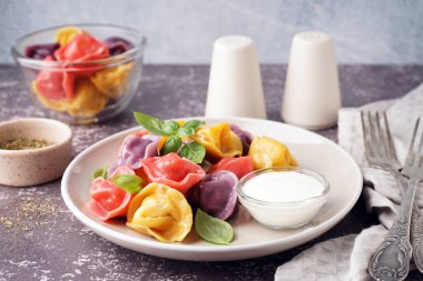 Koyu masada fesleğenli ve ekşi kremalı kaynamış hamur köftesi tabağı