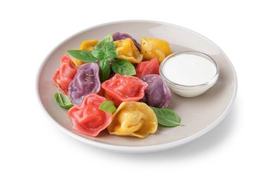 Beyaz arka planda fesleğenli ve ekşi kremalı kaynamış hamur köftesi tabağı.