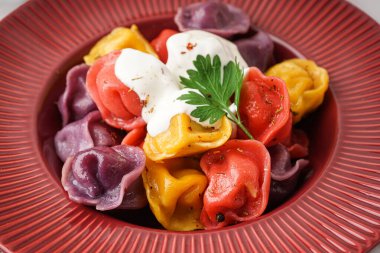 Ekşi kremalı ve maydanozlu kaynamış hamur köftesi tabağı, yakın plan.