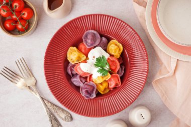 Beyaz arka planda ekşi kremalı ve maydanozlu kaynamış renkli hamur köfteleri.