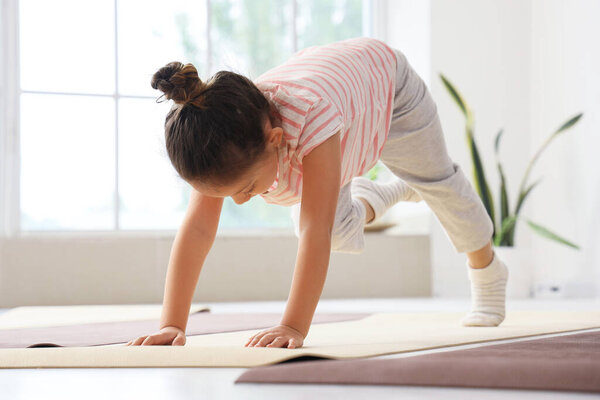 Little girl doing yoga in gym