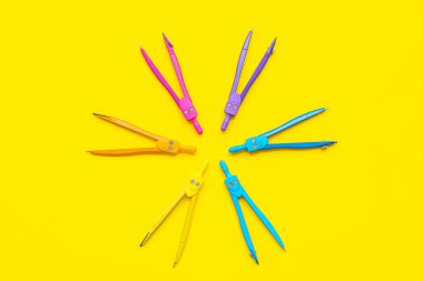 Sarı arkaplanda farklı pusulalarla kompozisyon