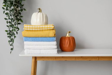 Işık duvarının yanındaki masada temiz havlu ve dekor yığını.