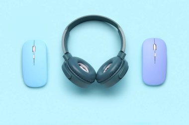 Mavi arka planda bilgisayar fareleri olan modern kulaklıklar
