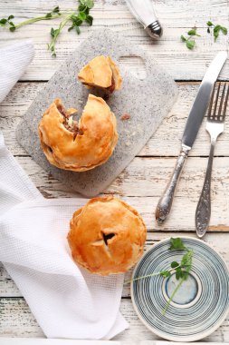 Hafif ahşap arka planda lezzetli etli börekler.