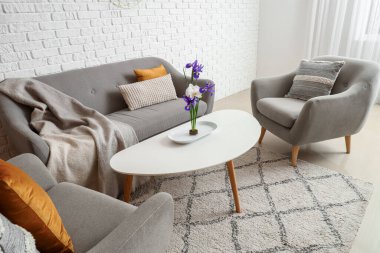 Oturma odasının içinde ikebana, koltuk ve koltuklar var.