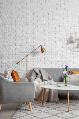Oturma odasının içinde ikebana, koltuk ve koltuk var.