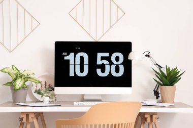 Işık ofisinde bilgisayar monitörü ve yapay tesisleri olan modern işyeri