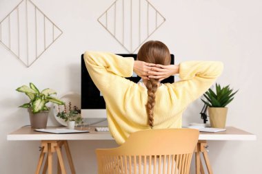 Ofisteki masada çalışan genç bir kadın.