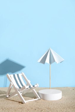 Dekoratif alçı podyum, güverte sandalyesi ve şemsiyeli yaratıcı kompozisyon.