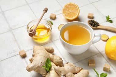 Beyaz fayanslı bir fincan zencefilli çay ve bal.