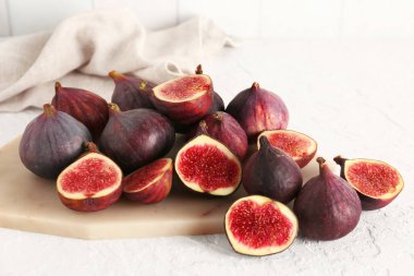 Beyaz arka planda taze olgun incirleri olan tahta