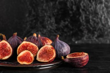 Siyah arka planda taze taze incir tabağı