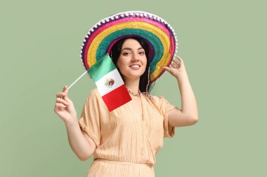 Sombrero 'daki güzel Meksikalı kadın ve yeşil arka planda bayrağı var.