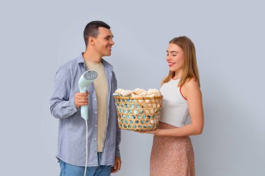 Buharlı tencere ve çamaşır sepetli genç bir çift.