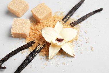 Aromatik vanilya şekeri, çiçek ve gri arkaplanda çubuklar