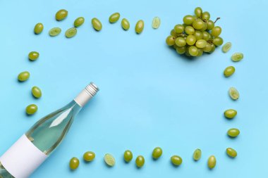 Mavi arka planda lezzetli şarap ve üzümlü şişeden yapılmış çerçeve.